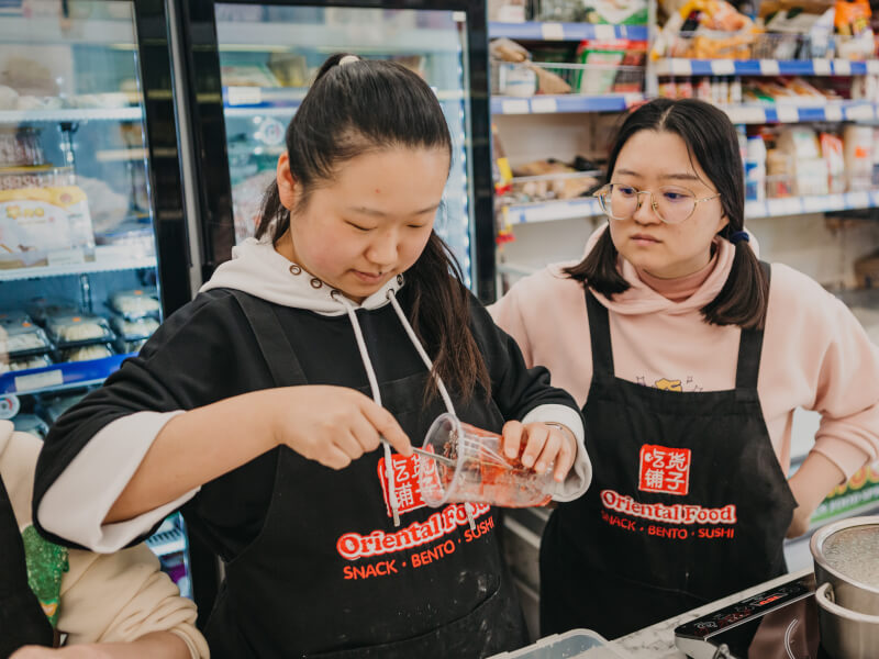Two people at a tea class preparing cups for bubble tea